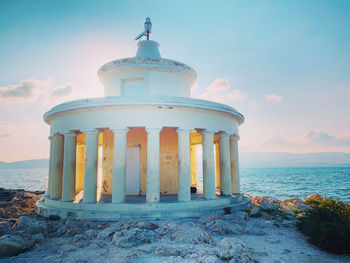 Lighthouse by sea against sky