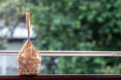 Close-up of glass hanging on railing against trees