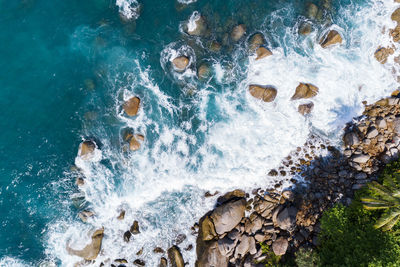 High angle view of wave splashing on rock