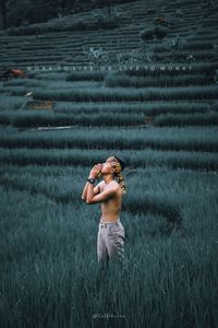 Side view of young man standing on field