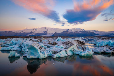 Scenic view of frozen lake against sky during sunset