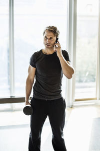 Man using mobile phone while exercising at gym