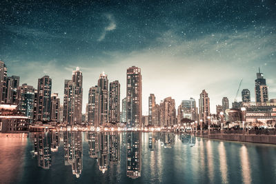 Digital composite image of illuminated buildings against sky