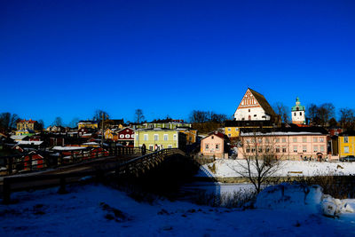 Snow covered townscape against blue sky