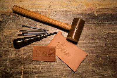 High angle view of tools with leather on wood at table