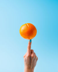 Close-up of hand holding orange