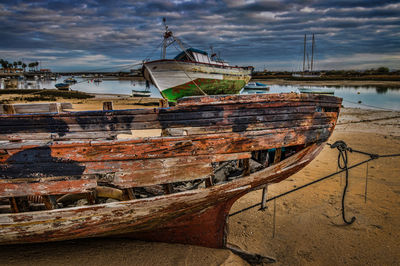 Boat moored on beach against sky