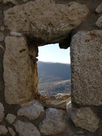 Rock formation against sky seen through window