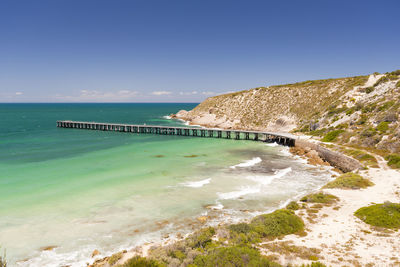 Long wooden jetty stretches out into clear water at stenhouse bay, south australia