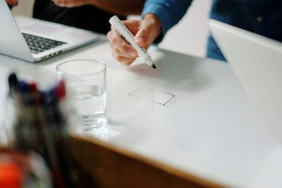 Midsection of businessman with coworker drawing on table at creative office