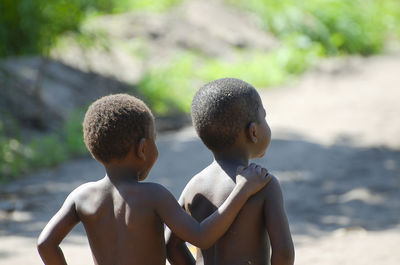 Rear view of shirtless boy in water