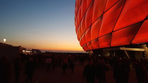 Crowd at town square against sky during sunset