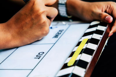 Close-up of hand writing in clapboard