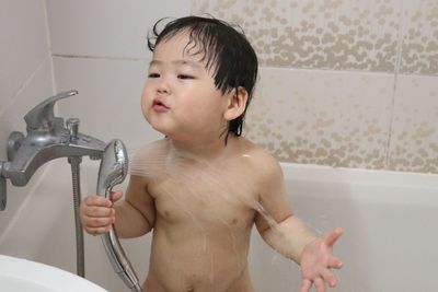 Close-up of baby boy playing in bathroom at home