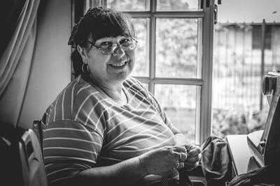 Portrait of smiling woman sitting at home