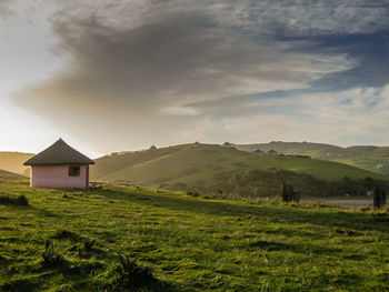 Scenic view of grassy field against cloudy sky