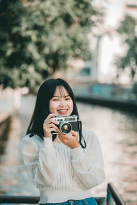 Portrait of young woman photographing