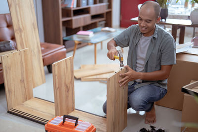 Portrait of man playing with toy blocks while sitting on table