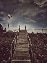 Pier on sea against cloudy sky