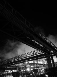 Low angle view of illuminated bridge against sky at night
