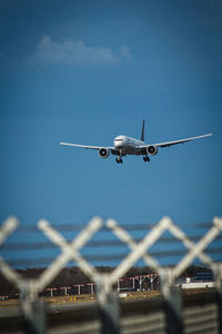 Low angle view of airplane flying against sky