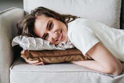 Beautiful woman lies on the sofa and smiles.