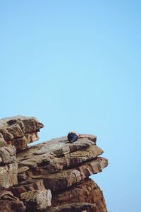 Low angle view of rock formation against clear blue sky