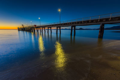 Pier on sea at sunset