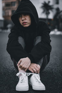 Full length of young man sitting in snow