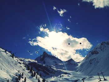 Scenic view of snowcapped mountains against blue sky