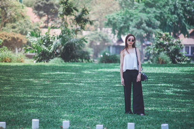 Portrait of young woman standing on field