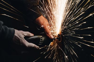 Cropped hands of worker grinding in factory