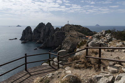 Scenic view of sea by cliff against sky