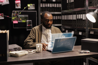 Portrait of young man using laptop at table