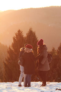 A group of three friends chatting on the snow in the dolomites