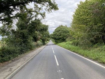 Looking along, common lane, with old trees, and a cloudy sky in, walton, wakefield, uk