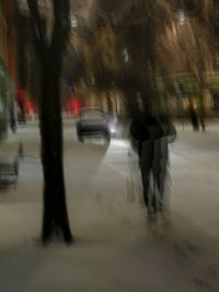 Blurred motion of person walking on street during winter
