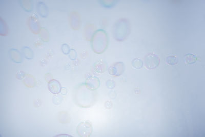 Close-up of bubbles flying against white background