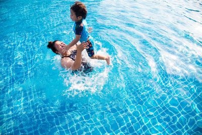 Full length of shirtless man swimming in pool