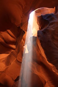 Low angle view of sunlight falling on rock formation at canyon