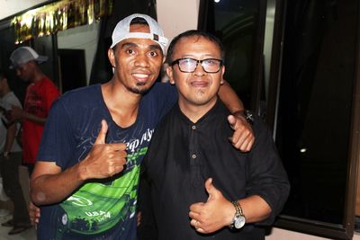 Portrait of male friends showing thumbs up sign