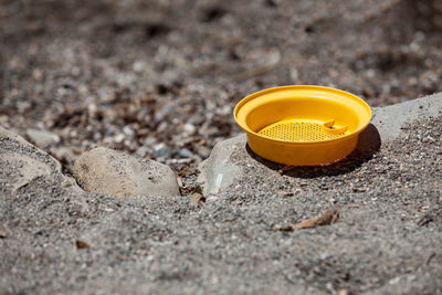 High angle view of yellow container on rock