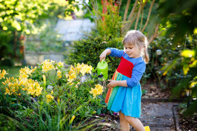 Full length of woman standing on flowering plant
