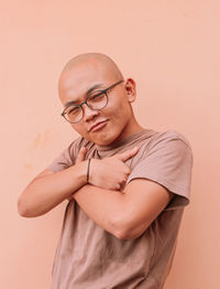 Portrait of young man standing against wall
