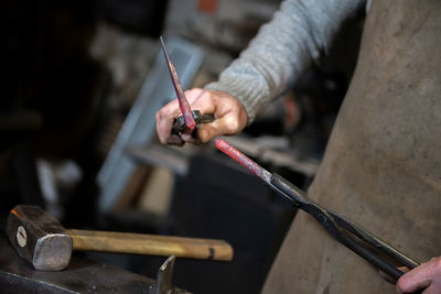 Midsection of blacksmith in workshop