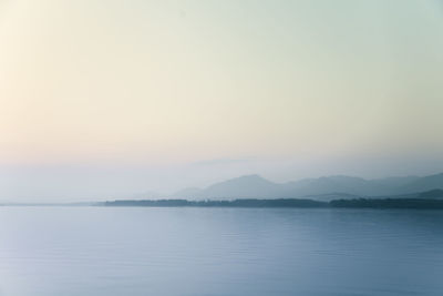 Scenic view of lake against clear sky during sunset