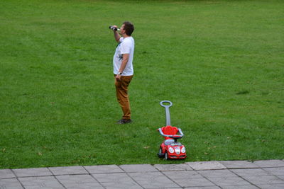 Rear view of man photographing on footpath