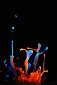 Close-up of multi colored light painting against black background