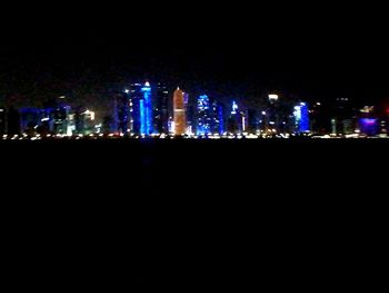 Illuminated buildings against sky at night