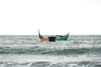 A pair of traditional fishing boats, going out to sea, looking for fish